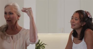 Mutfak adasında dizüstü bilgisayar ve dizüstü bilgisayarla tasarlanan kolye hediyesine tepki gösteren çeşitli arkadaşlar. Arkadaşlık, kutlama, mücevher, işbirliği, modern, yaşam tarzı, iç mekan