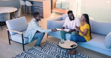 Afrika kökenli Amerikalı bir ajanın Afrika kökenli Amerikalı bir aileye davetiye dağıtması. Modern, aile, kutlama, etkileşim, ev, yaşam tarzı, neşe