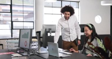 Mutlu iş adamı ve iş kadını tezahüratı, beşlik çakma, ofiste dizüstü bilgisayar kullanma. İş, iş, ofis ve çalışma ortamı kavramı.