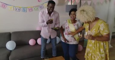 Çeşitli arkadaşlar bebek partisini evde kutluyor, atıştırmalıkların ve canlı sohbetin tadını çıkarıyorlar. Kutlama, arkadaşlık, toplanma, etkinlik, mutluluk, parti