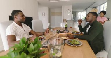 Çeşitli arkadaşlar evde yemek ve içeceklerin tadını çıkarıyor, birlikte kutluyorlar. Kutlama, dostluk, yemek, toplanma, yaşam tarzı, içeride