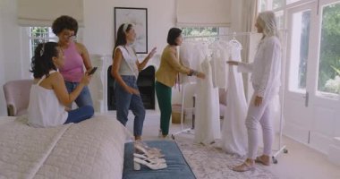 Gelinliği denetleyen arkadaşlarla yatak odasındaki Asyalı gelin koltuğunda düğün danışmanlığı. Gelin, zarafet, kutlama, moda, kadınlık, ilham, olay