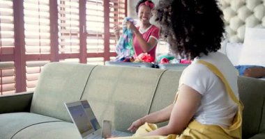 Kadın dizüstü bilgisayarla uçuyor, ortağı bavula uzanıyor. Seyahat, tatil, planlama, lezbiyen çift, teknoloji, yolculuk