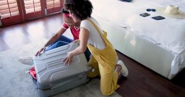 Afro-Amerikalı kadınlar evlerinde bavullarını toplayıp seyahate hazırlanıyorlar. tatil, hazırlık, bagaj, birliktelik, bağ, arkadaşlık