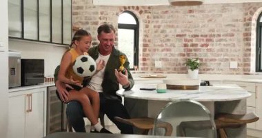 Baba-kız mutfakta kaynaşıp babamın yanına meyve suyu koyuyorlar. Kupayı futbol topuyla gösteriyorlar. Aile, akıl hocalığı, başarı, bağlantı, kutlama, sıcaklık, yurt içi