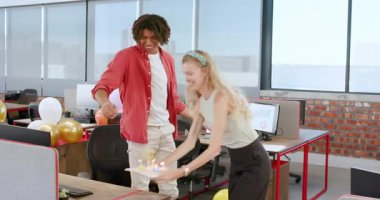 Çeşitli iş arkadaşları modern ofiste doğum gününü kutluyor renkli balonlarla pastaya hayran kalıyorlar. Kutlama, takım çalışması, ofis, dekor, meslektaşlar, neşe, verimlilik