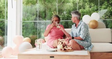 Modern aydınlık evde 60. yaş gününü pastayla kutlayan kıdemli arkadaşlar. Doğum günü, kutlama, dostluk, sağlık, modern, canlı, neşe