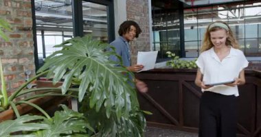 Çeşitli iş arkadaşları modern ofisteki belgeleri inceliyor, ellerinde belgeler ve tablet var. İşbirliği, tartışma, çalışma alanı, modern, profesyonel, takım çalışması, yaratıcılık