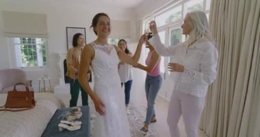 Stüdyoya giren Asyalı gelinler flüt kızartırken elbisenin bağcıklarına hayranlık duyuyorlar. Düğün, kutlama, zarafet, kadınlık, moda, mutluluk, arkadaşlık