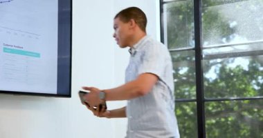 İş adamı, modern ofisteki konferans odasında iş kadınına tablet sunumu yapıyor. İş, iş ve ofis ortamı kavramı.