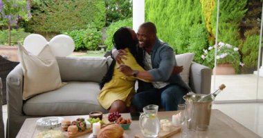 Dışarıda brunch 'ın tadını çıkaran, içki dolduran ve masaya atıştırmalık şeyler koyan bir çift. Toplantı, eğlence, içecekler, sosyalleşme, haftasonu, arkadaşlık