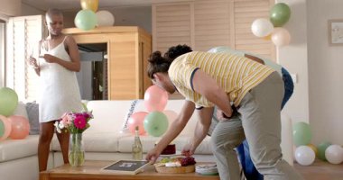 Evde kutlama, arkadaşlar balonlar ve çiçeklerle neşeli anlar paylaşıyorlar. Parti, kutlama, dostluk, mutluluk, dekorasyon, şenlik