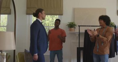 Stüdyoda kadeh kaldıran çeşitli erkek arkadaşları ve meslektaşlarıyla takım elbise provası yapan bir müşteri. Profesyonel, yoldaşlık, modern, işbirliği, ağ oluşturma, sofistike, şık