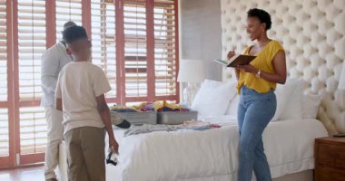 Aile bavullarını yatağa topluyor, tatile hazırlanıyor, seyahat planlarını evde tartışıyoruz. planlama, bagaj, hazırlık, yolculuk