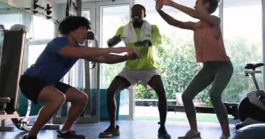 Genç yetişkinler birlikte spor yapıyor, gülümsüyor ve antrenmandan zevk alıyorlar. Fitness, egzersiz, motivasyon, eğitim, takım çalışması, sağlık