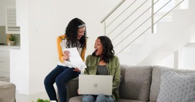 Anne ve kızı belgeleri paylaşıyor ve dizüstü bilgisayarla mektup okuyor. Aile, bağlantı, iletişim, öğrenme, teknoloji, ev, sıcaklık