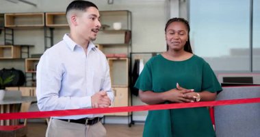 Muhtelif iş arkadaşları ofiste kırmızı kurdele kesiyor, gülümsemelerini paylaşıyor ve makas kullanarak odaklanıyorlar. Tören, takım çalışması, kutlama, başarı, profesyonellik, işbirliği, odaklanma