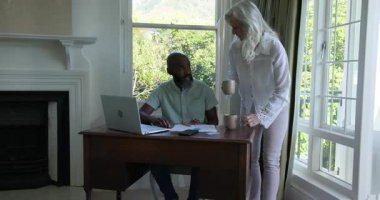 Üst düzey çift, kahve kupası teslimatından sonra çalışma masasında evrakları gözden geçirip daktilo yazıyorlar. Profesyonel, işbirliği, çalışma alanı, modern, yerli, sıcak, nişanlı