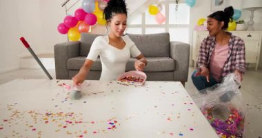 Oturma odasında konfetileri süpüren çeşitli bayan arkadaşlar, fırça ve faraşla. Temizlik, sonuç, yerli, modern, minimalist, enerjik, samimi