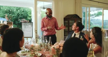 Olgun siyahi bir adam damadın omzuna dokunup şampanya kadehleriyle düğün kadehlerini kaldırıyor. Kutlama, zarafet, birlik, sosyal birleşme, sofistike, mutluluk, açık hava