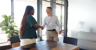 Modern ofiste yürüyen çeşitli meslektaşlar, akıllı telefon, dizüstü bilgisayar ve kağıtlarla kutlama yapıyorlar. Kutlama, takım çalışması, etkileşim, iletişim, modern, yeşillik, işbirliği