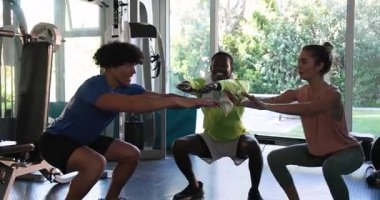 Genç yetişkinler spor salonunda birlikte gülüyor ve egzersiz yapıyorlar. Egzersiz yapmaktan zevk alıyorlar. Fitness, egzersiz, sağlıklı yaşam tarzı, arkadaşlık, grup aktivitesi, aktif