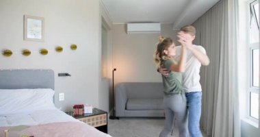 Sıcak yatak odasında neşeyle dans eden çift sabahları birlikte evde başlıyor. Mutluluk, dans, ilişki, yaşam tarzı, samimiyet, birliktelik