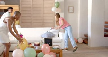 Yeni işi kutlamak, arkadaşlar oturma odasını balonlar ve pastayla süslemek. Kutlama, dostluk, mutluluk, parti, takım çalışması, yeni başlangıçlar