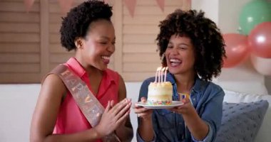 Doğum gününü kutlayan, çeşitli kadın çiftler ellerinde mumlarla ellerinde pasta tutuyorlar. Kutlama, arkadaşlık, mutluluk, parti, kapalı mekanlar, birliktelik