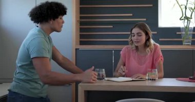 Genç çift mutfak tezgahında planları tartışıyor, birlikte notlar yazıyorlar, evde. Planlama, takım çalışması, işbirliği, yerli, yaşam tarzı, ilişki