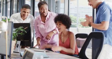 Çeşitli meslektaşlar modern ofiste ödül törenini kutluyor, dizüstü bilgisayarları ve belgeleri inceliyor. Tören, takım çalışması, katılım, profesyonellik, işbirliği, işyeri, tanınma