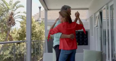 Balkonda dans eden yaşlı çift, elini tutan ve Hasır Kanepe 'den ona rehberlik eden adam. Romantizm, bağlantı, arkadaşlık, rahatlık, zarafet, sükunet, açık hava