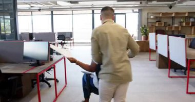 Genç ve çeşitli erkekler modern ofiste ofis sandalyesini iterken Afro-Amerikalı kadın gülüyor. Elveda, kutlama, takım çalışması, ofis, modern, kahkaha, verimlilik