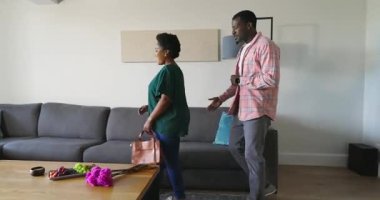 Kanepede oturan çeşitli çiftler televizyonu işaret ederken tartışıyorlar. Aile, ev, oturma odası, tartışma, iletişim, teknoloji