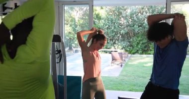 Genç çift evde birlikte geriniyor, sabah egzersizlerinin keyfini çıkarıyor, evde spor yapıyor. Fitness, sağlık, yoga, ev çalışması, yaşam tarzı