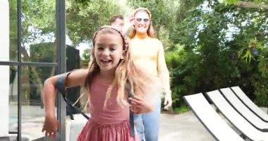 Birçok ebeveyn kapı açıldıktan sonra evi keşfediyor, kız sırt çantasıyla atlıyor ve baba çantasını yuvarlıyor. Aile, yerli, modern, yaşam tarzı, açık hava, boş zaman, bağlantı