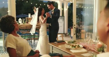 Yeni evli çift, misafirler içeri girip alkışladıktan sonra sicim ışıkları altında ilk dansta rehberlik ediyor. Romantik, kutlama, zarafet, ortam, samimiyet, neşe, konukseverlik