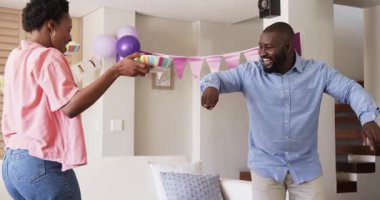 Afro-Amerikalı çift evde renkli kaseler taşıyan bir partiye hazırlanıyor. Kutlama, birliktelik, dekorasyon, şenlik, toplanma, düzenleme