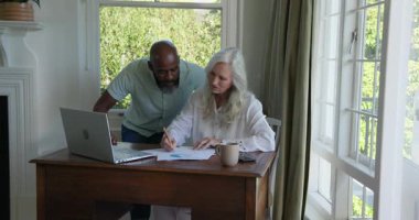 Üst düzey bir çift parlak ev ofisine giriyor ve raporu tamamlamak için dizüstü bilgisayardaki çizelgeleri inceliyor. İşbirliği, ortaklık, üretkenlik, meslek, başarı, iletişim, motivasyon