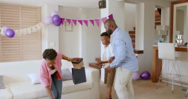 Afro-Amerikan ailesi evde balonlar ve hediyelerle kutlamaya hazırlanıyor. Şenlik, birliktelik, mutluluk, neşe, birlik