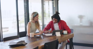 Modern toplantı odasında tablet ve kahve fincanlarıyla ciddi ciddi sohbet eden çeşitli çiftler. Çalışma alanı, işbirliği, tartışma, profesyonellik, şeffaflık, teknoloji, ortam