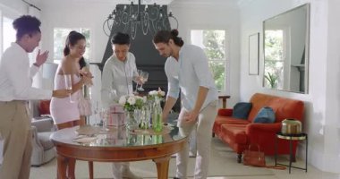 Çeşitli arkadaşlar evde hediyelerle cam masa hazırlıyorlar, şampanya dolduruyorlar ve masaları temizliyorlar. Kutlama, sosyalleşme, zarafet, ortam, arkadaşlık, eğlence, konukseverlik