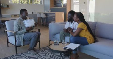 Afro-Amerikalı arkadaşlar modern evlerde tablet ve jestlerle sohbet ediyorlar. Konuşma, modern, minimalist, arkadaşlık, bağlılık, sıcaklık, yaşam alanı, etkileşim