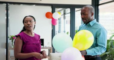Afrika kökenli Amerikalı arkadaşlar ofis doğum gününü kutluyor ellerinde renkli balonlar ve gülümsüyorlar. Kutlama, dostluk, neşe, ofis, balonlar, parti, coşku