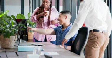 Ofisteki çeşitli iş arkadaşları kahve fincanı ve gazetelerle bilgisayar monitörü üzerinde işbirliği yapıyorlar. İşbirliği, takım çalışması, modern, çalışma alanı, katılım, tartışma, profesyonel