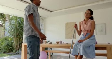 Çeşitli çiftler evde süpürge, parti malzemeleri ve bisikletle eğlenceli sohbetler yapıyorlar. Kutlama, ev, parti, etkileşim, parlaklık, dekor, gençlik, şakacı, evcil