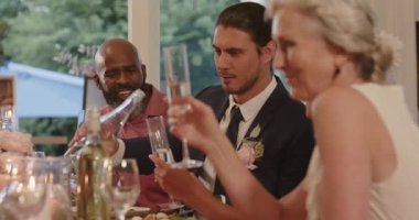 Olgun siyah adam düğün kadehlerine başlıyor, gelin ve damat kadehlerine şampanya dolduruyor, fotokopi odası. Kutlama, zarafet, neşe, sofistike, arkadaşlık, birlik, ortam