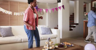 Evde kutlama yapıyoruz, neşeli bir çift parti için atıştırmalık bir şeyler hazırlıyor. Kutlama, dekorasyon, arkadaşlık, mutluluk, kaynaşma