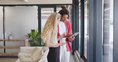 Çift modern ofis alanında yeni bir işe başlıyor, tablet ve akıllı telefon kullanarak planları tartışıyorlar. İşbirliği, teknoloji, çalışma alanı, büyüme, profesyoneller, iletişim, iyimserlik