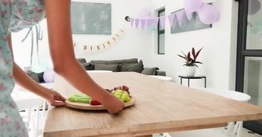 Yemek odasına giriyorlar, çeşitli bayan arkadaşlar doğum günü partisi için yemek tabakları ve hediyeler hazırlıyorlar. Kutlama, dostluk, dekor, yaşam tarzı, şenlik, topluluk, modern